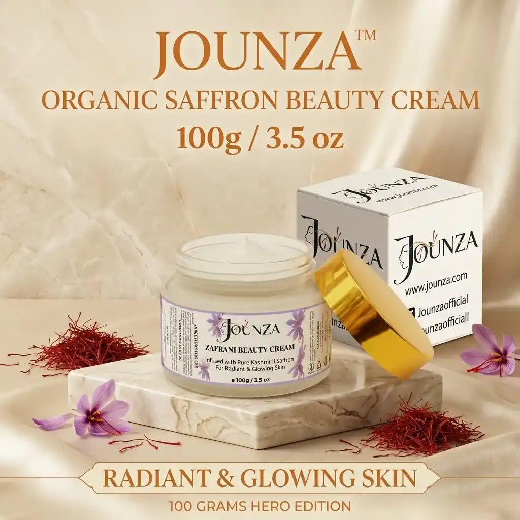 Jounza Organic Saffron Beauty Cream 100g / 3.5 oz Hero Edition product image. Features the open cream jar on a marble slab, surrounded by organic saffron strands and purple saffron flowers next to its branded packaging box.