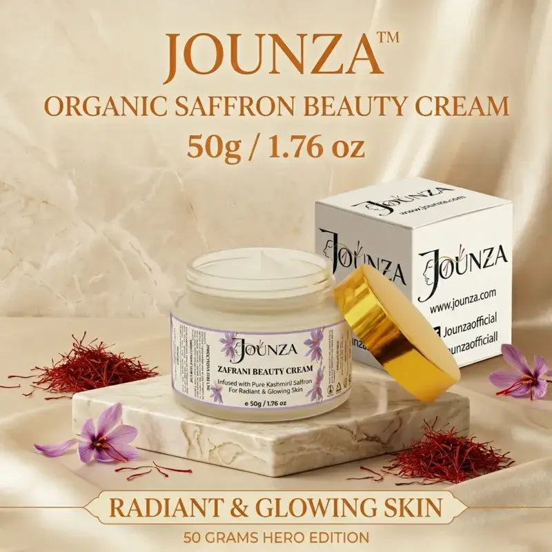 Jounza Organic Saffron Beauty Cream 50g / 1.76 oz Hero Edition product image. Displays the open 50g cream jar on a white marble base, surrounded by organic saffron strands and purple flowers next to its branded white and gold packaging box